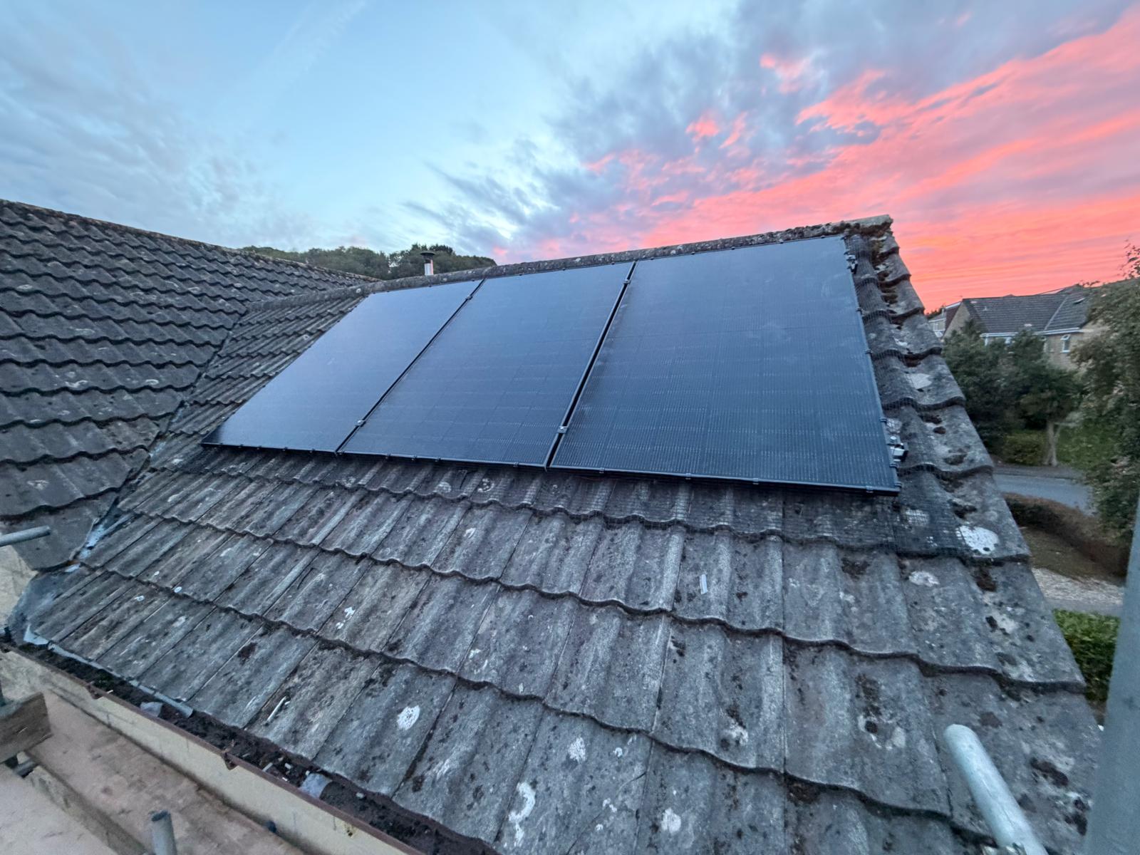 Bird protection mesh beside solar panels on a weathered roof